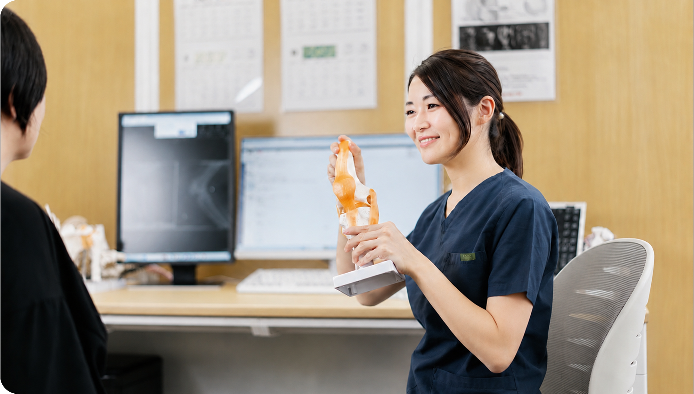 スタッフが膝関節の模型を使って患者に説明している様子
